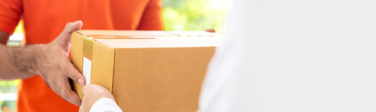 Courier service delivery man in orange uniform giving parcel box to customer at home, panoramic banner with copy space